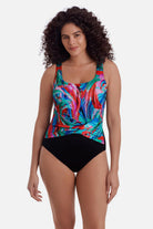Woman wearing a multicolor abstract printed one-piece swimsuit with a sash detail