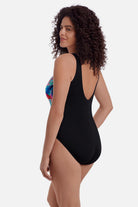 Woman turned left wearing a multicolor abstract printed one-piece swimsuit