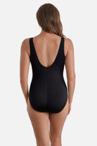 Woman turned away wearing a one-piece swimsuit with a scoop back