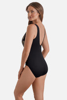 Woman turned left wearing a gold and white floral pattern one-piece swimsuit with a pull sash