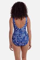Woman faced away wearing a blue and white floral printed one piece swimsuit