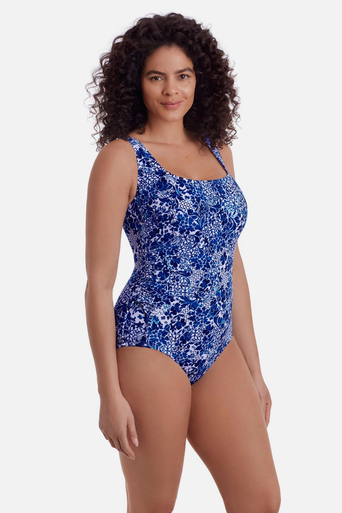 Woman faced right wearing a blue and white floral printed one piece swimsuit