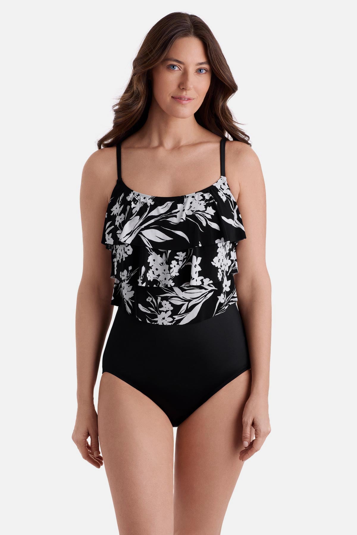 Woman wearing a black and white floral printed one-piece swimsuit with a triple tier tank