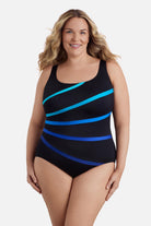 Woman wearing an ombre black and blue striped one-piece swimsuit
