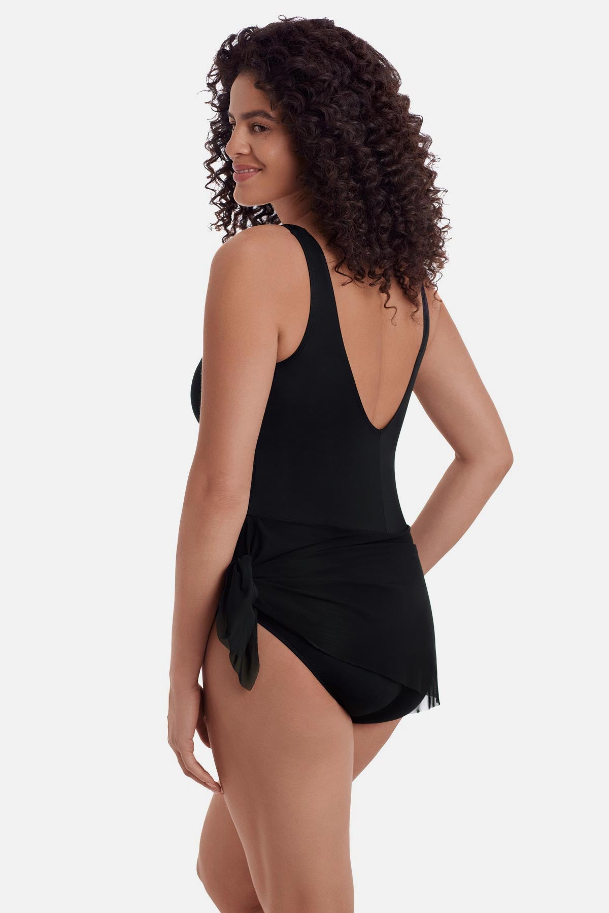 Woman turned left wearing a black one-piece swimsuit with a black wrap sash around the waist