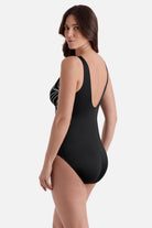 Woman turned left wearing a black and white fern printed swimsuit 