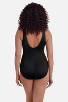 Woman turned away wearing a multicolored palm leaf one-piece swimsuit 