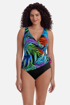 Woman wearing a multicolored palm leaf one-piece swimsuit with side tie detail