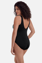 Woman turned left wearing a multicolored palm leaf one-piece swimsuit 