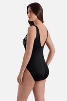 Woman turned left wearing a gold and white floral printed one piece 