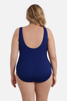 Woman faced away wearing a navy blue abstract printed one-piece swimsuit 
