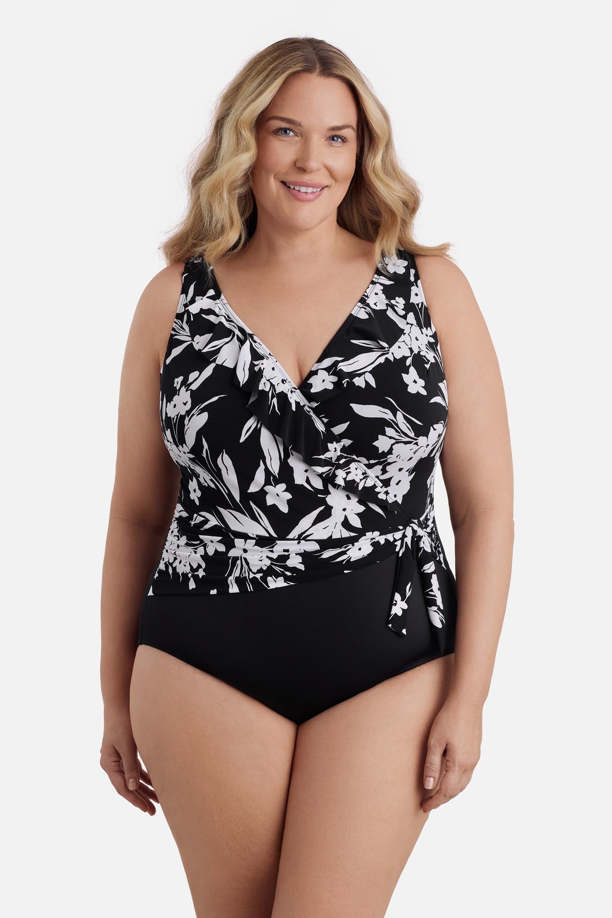 Woman wearing a black and white floral one-piece swimsuit