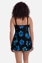 Woman turned away wearing a black swim dress with large blue flowers