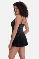 Woman turned left wearing a black and white speckled swim dress 