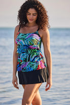 Woman on beach wearing a multicolor palm leaf print faux ruffle skirtini swimsuit