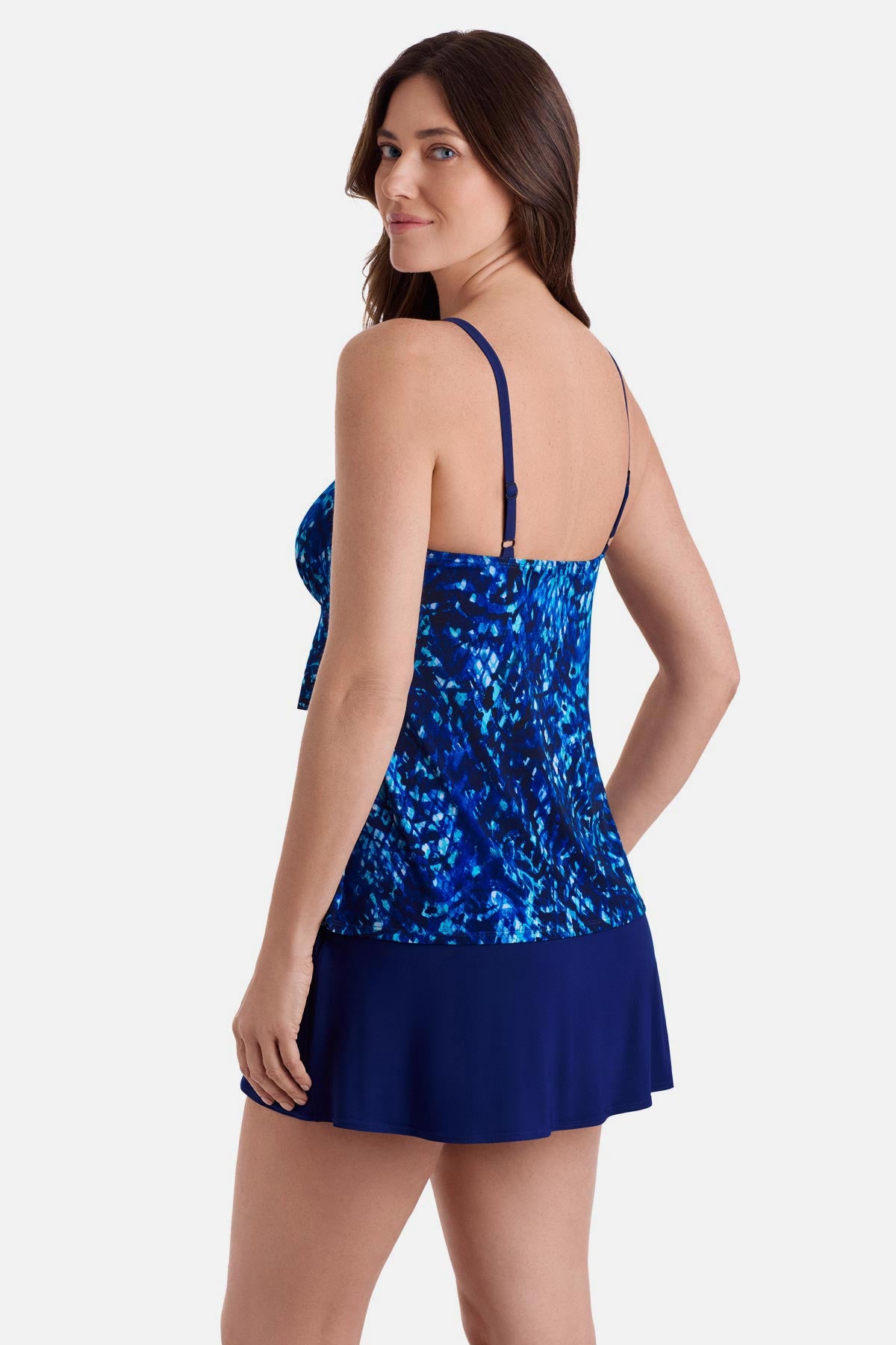 Woman turned left wearing a blue abstract print ruffle skirtini swimsuit