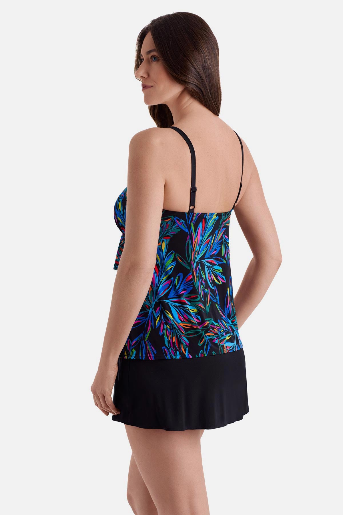 Woman turned left wearing an abstract rainbow printed faux ruffle skirtini swimsuit