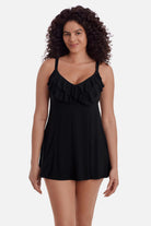 Woman wearing a black swim dress with ruffles on the neckline 