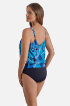 Woman turned left wearing a blue floral printed one-piece blouson swimsuit