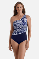 Woman wearing a blue and white abstract floral printed one shoulder one-piece swimsuit