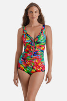Woman wearing a multicolor palm leaf printed one-piece swimsuit with ruffles down the front