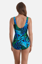 Woman turned away wearing a blue and green one-piece swimsuit with ruffles down the front