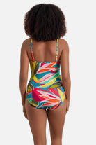 Woman turned away wearing a multicolored abstract printed one-piece swimsuit