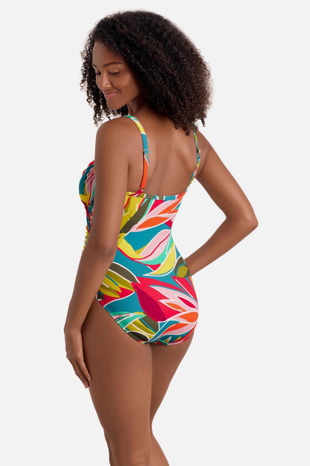 Woman turned left wearing a multicolored abstract printed one-piece swimsuit