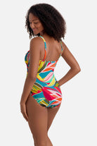Woman turned left wearing a multicolored abstract printed one-piece swimsuit