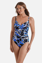 Woman wearing a black, blue and white floral printed one-piece swimsuit