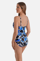 Woman turned left wearing a black, blue and white floral printed one-piece swimsuit