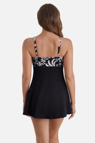 Woman turned away wearing a black and white palm tree printed swim dress