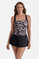 Woman wearing an animal skin printed skater swim dress with a black skirted bottom