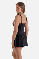 Woman turned left wearing an animal skin printed skater swim dress with a black skirted bottom