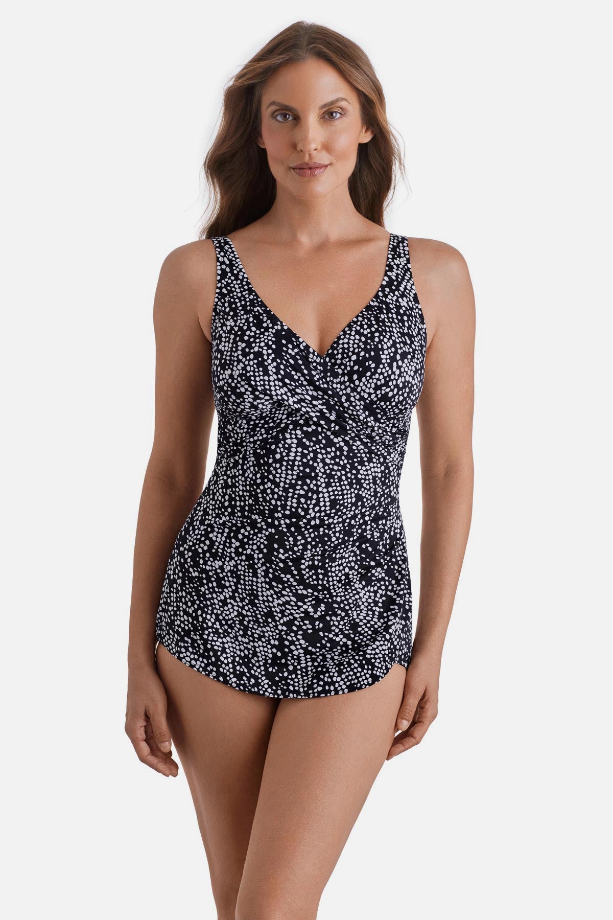 Woman wearing a black and white dot printed one-piece swimsuit