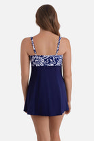 Woman turned away wearing a blue and white abstract floral printed swim dress