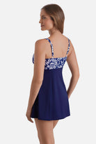 Woman turned left wearing a blue and white abstract floral printed swim dress