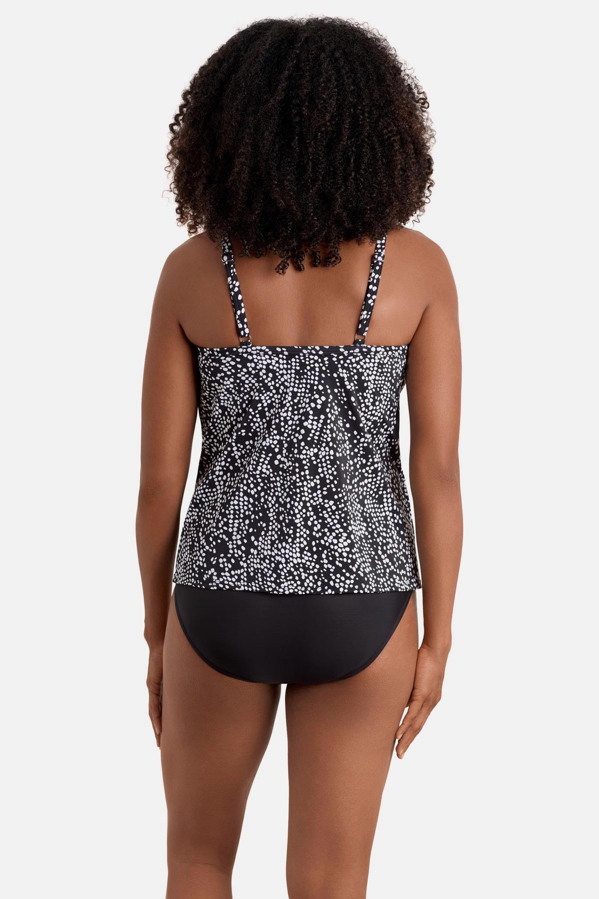 Woman turned away wearing a black and white dot printed high neck tankini top