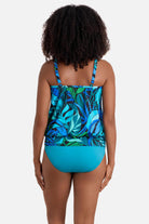 Woman turned away wearing a blue and green palm leaf printed blouson tankini top