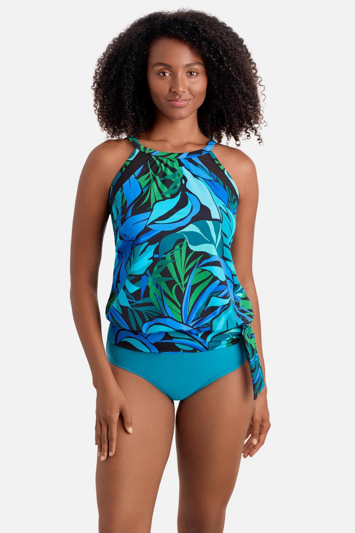 Woman wearing a blue and green palm leaf printed blouson tankini top