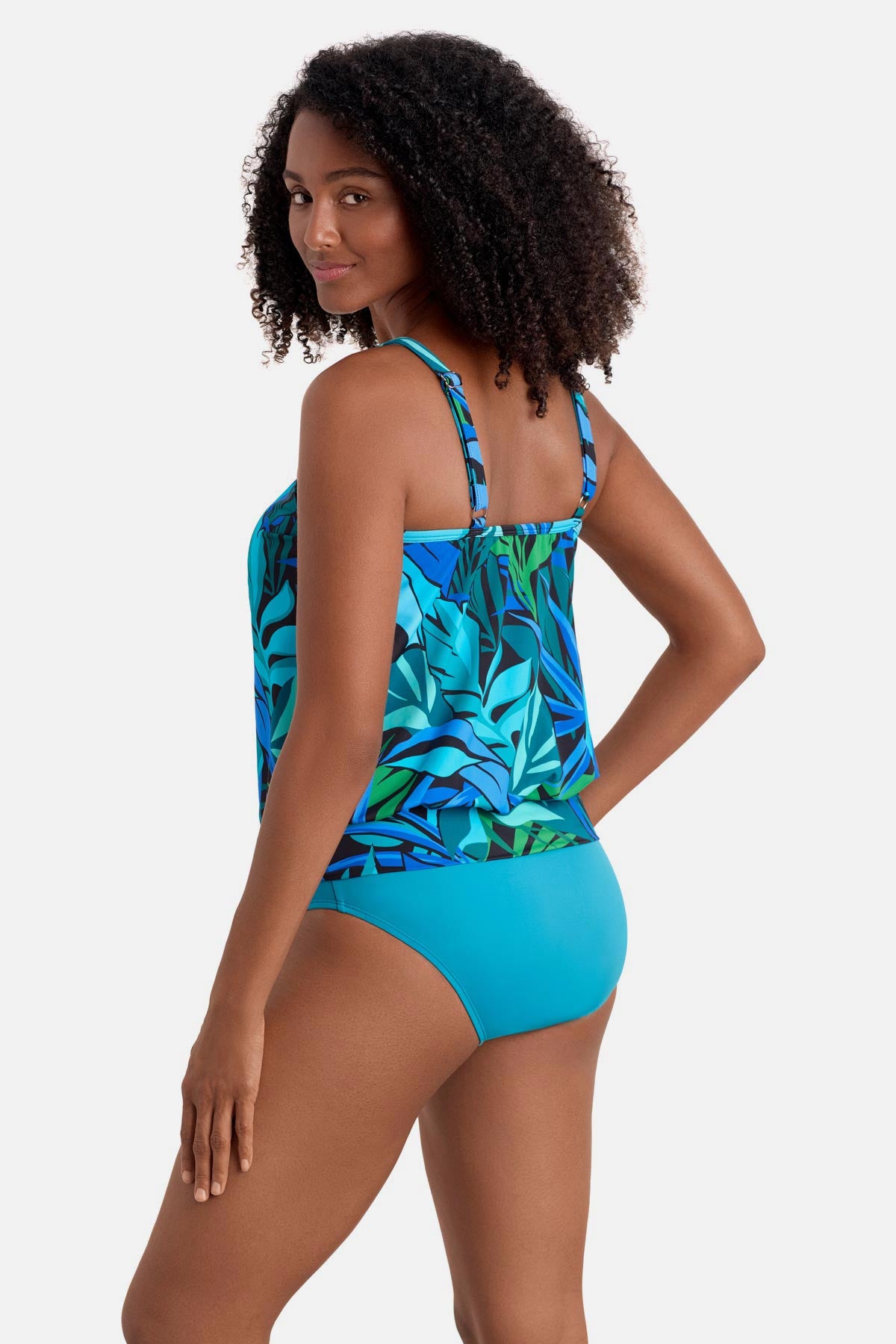 Woman turned left wearing a blue and green palm leaf printed blouson tankini top
