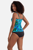 Woman turned left wearing a blue and green palm leaf print square neck tankini top