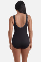 Woman turned away wearing a black one-piece swimsuit with black and white piping on the edges