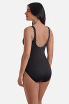 Woman turned left wearing a black one-piece swimsuit with black and white piping on the edges