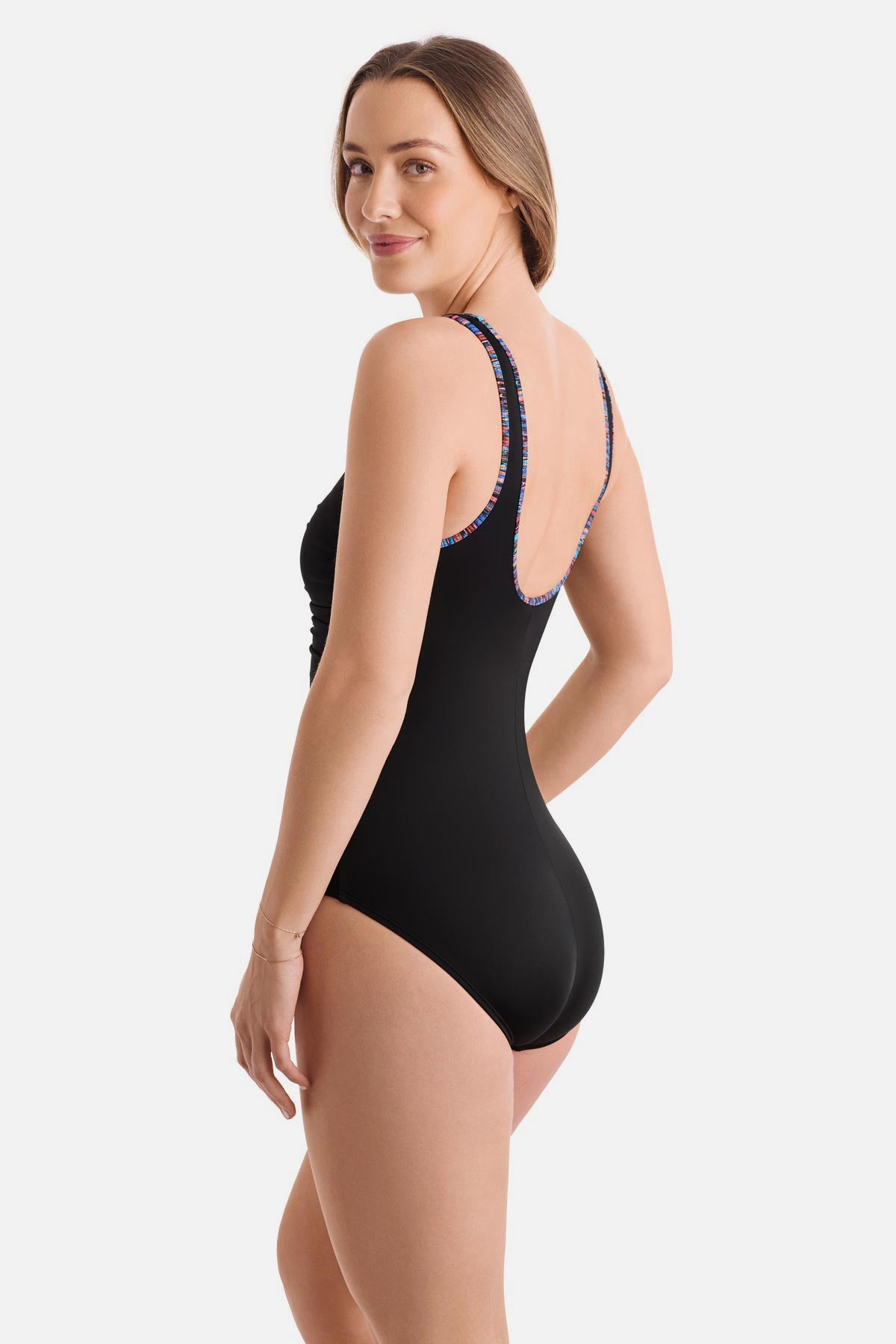 Woman turned left wearing a black one-piece swimsuit with rainbow piping
