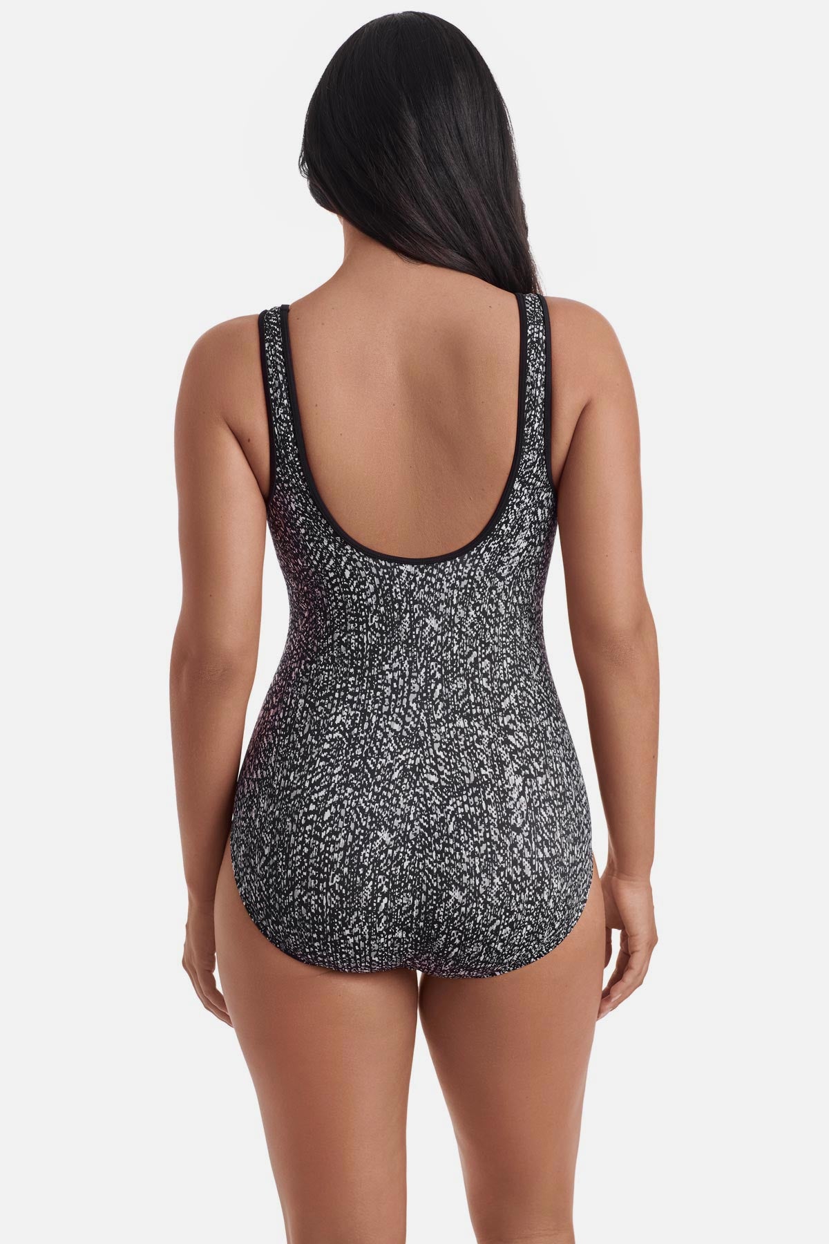 Woman turned away wearing a black and white static print one-piece swimsuit 