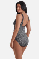 Woman turned left wearing a black and white static print one-piece swimsuit with a zipper down the front