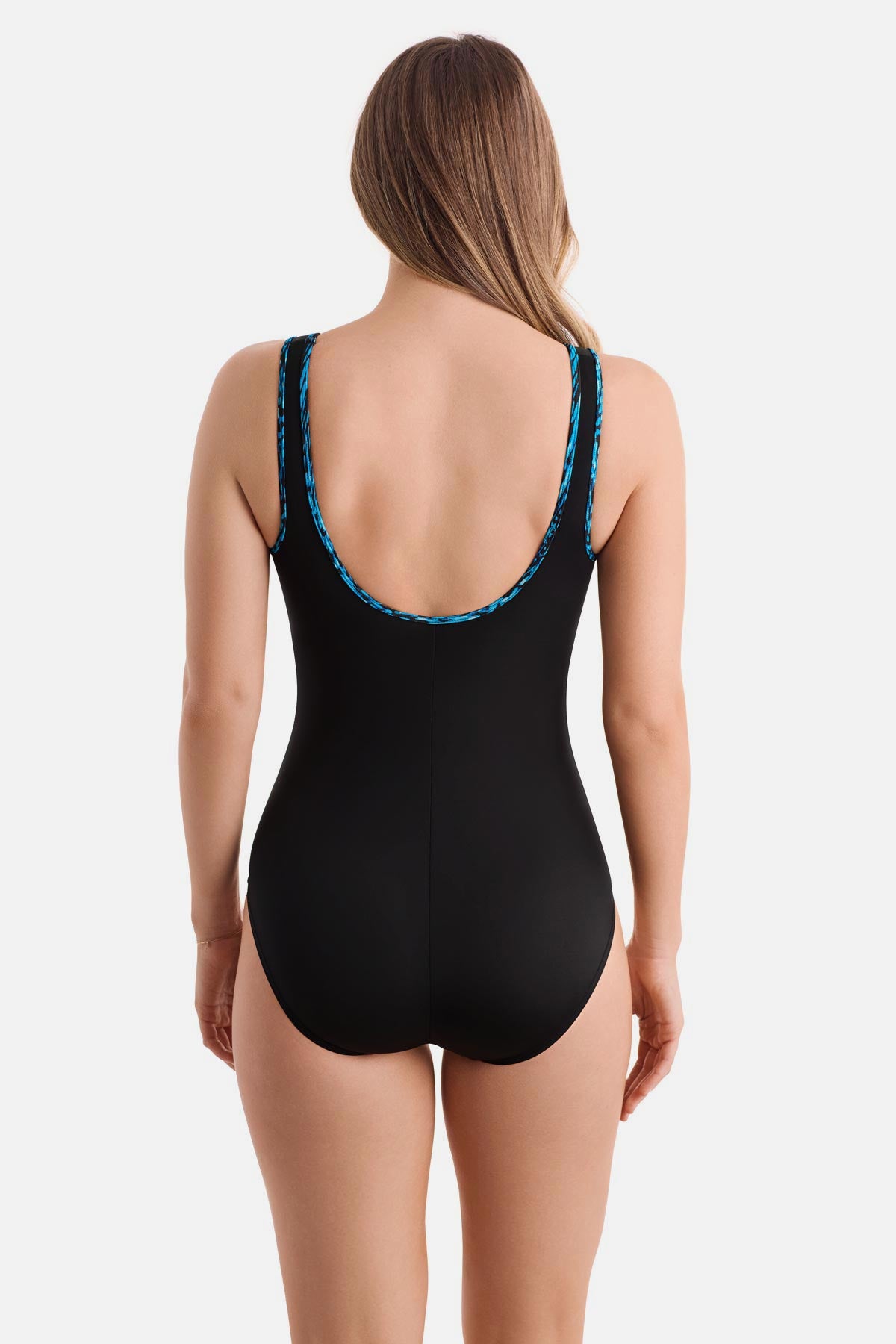 Woman turned away wearing a black one-piece swimsuit with a blue braided piping on the edges