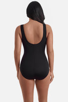 Woman turned away wearing a black one-piece swimsuit 