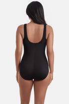Woman turned away wearing a black and white abstract pattern one-piece swimsuit